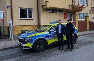 Na zdjęciu w policyjnym mundurze komisarz Tomasz Bajda Komendant Komisariatu Policji w Tyczynie z Burmistrzem Tyczyna Januszem Błotnickim, obok nich policyjny radiowóz.