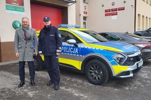 Na zdjęciu w policyjnym mundurze komisarz Tomasz Bajda Komendant Komisariatu Policji w Tyczynie z Wójtem Gminy Chmielnik Krzysztofem Grad, obok nich policyjny radiowóz.