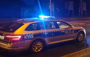 Na zdjęciu policyjny radiowóz z włączonymi światłami uprzywilejowania.