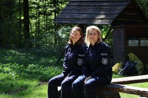 Na zdjęciu dwie umundurowane policjantki siedzące na ławce.