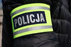 Na zdjęciu odblaskowa opaska ramienna z napisem policja.