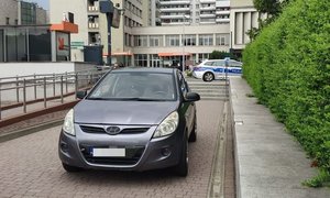 Na zdjęciu pojazd marki Hyundai, w oddali policyjny radiowóz.