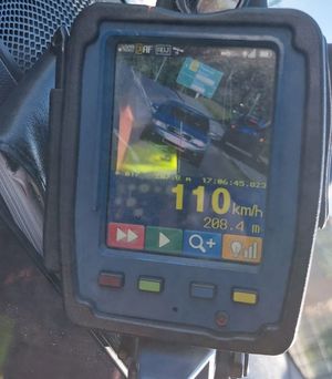 Na zdjeciu wyświetlacz ręcznego miernika prędkości z zarejestrowanym pojazdem, który przekroczył dopuszczalną prędkość i jechał 110 km/h, na drodze z ograniczeniem do 50 km/h.