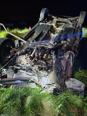 Na zdjęciu przewrócony na dach samochód w rowie.