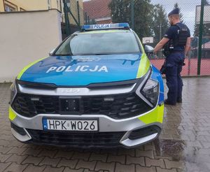 Na zdjęciu umundurowany policjant przy radiowozie.