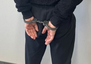 Na zdjęciu mężczyzna, który na rękach trzymanych z tyłu ma założone kajdanki.