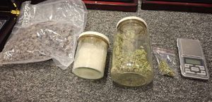 Na zdjęciu worek z suszem roślinnym, dwa słoiki z narkotykami.