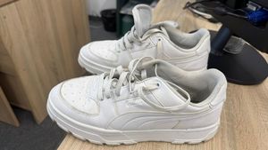 Na zdjęciu białe sportowe buty.