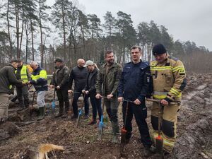 Na zdjęciu zaproszeni goście przygotowujący się do sadzenia drzewek.