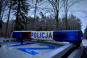 baner POLICJA w tle drzewa