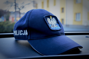 policyjna czapka na kokpicie radiowozu