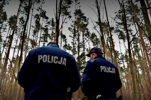 policjanci, w tle drzewa