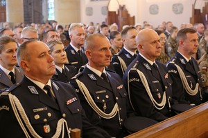 Policjanci siedzący w kościelnych ławach podczas uroczystości patronalnych w Miejscu Piastowym