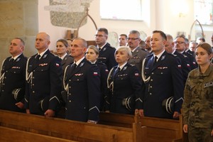 Policjanci siedzący w kościelnych ławach podczas uroczystości patronalnych w Miejscu Piastowym