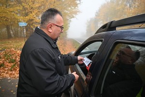 urzędnik gminny rozdaje ulotki podczas policyjnej kontroli stanu trzeźwości kierowców