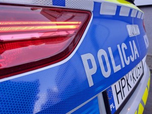 tylna część radiowozu z napisem policja na niebieskim tle