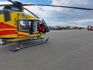 śmigłowiec LPR, w tle pojazdy służb ratowniczych