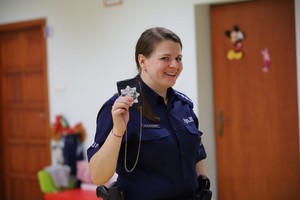 Funkcjonariuszka prezentująca policyjną odznakę