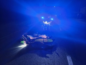 policyjny motocykl oraz leżący na ulicy jednoślad uczestniczący w ucieczce