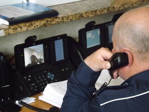 Stanowisko oficera dyżurnego KPP Dębica, policjant odbiera telefoniczne zgłoszenie.