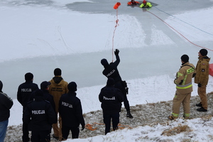 Policjant podczas rzutu rzutką ratunkową