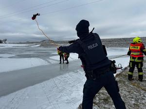 Policjant rzuca rzutkę ratunkową w miejsce pozoranta w wodzie