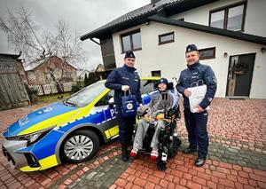 Policjanci wspólnie z Wojtkiem obok radiowozu