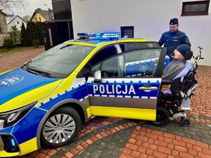 Policjanci wspólnie z Wojtkiem obok radiowozu