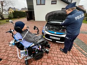 Policjanci wspólnie z Wojtkiem obok radiowozu