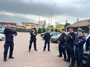 Na zdjęciu widoczni umundurowani funkcjonariusze policji stojący na placu przy Komendzie Powiatowej Policji w Brzozowie podczas odprawy do służby.