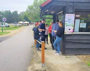 Policjanci rozmawiają z osobami o bezpiecznych wakacjach na terenie ośrodka GOWIR Radawa
