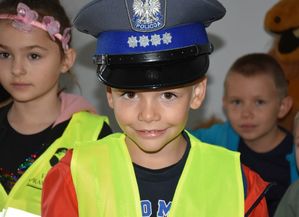 Chłopczyk w kamizelce i czapce policyjnej - zdjęcie portretowe