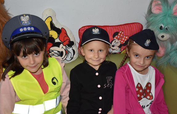 Trzy dziewczynki w policyjnych czapkach
