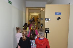 Dzieci przechodzą przez pomieszczenie dla osób zatrzymanych