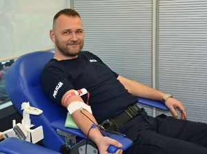 Policjant oddaje krew w krwiobusie