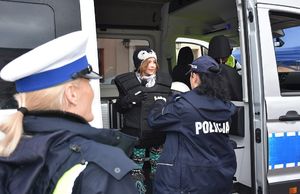 Policjantka zakłada dziecku kamizelkę kuloodporną