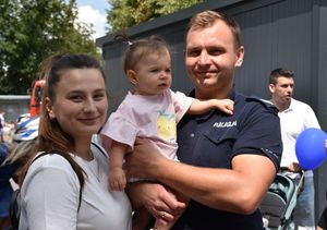 Kobieta i policjant z dzieckiem na rękach