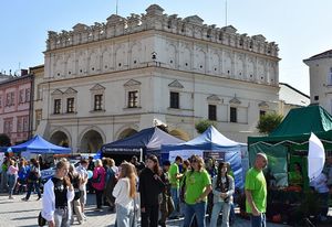 W tle kamienica. Przed nią policyjne stoisko przed którym znajdują się osoby