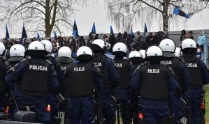 Policjanci oddziału prewencji. W tle kibice na trybunach