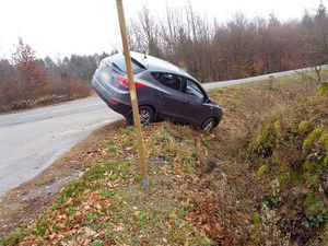 Samochód w przydrożnym rowie. Tył pojazdu znajduje się nad jezdnią.