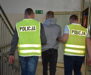 Policjanci prowadzą osobę zatrzymaną