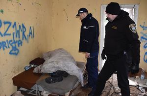 Policjant i strażnik miejski kontrolują miejsca przebywania osób w pustrostanach