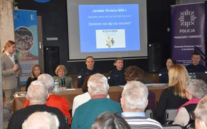 Seniorzy na debacie. W tle ekran na którym wyświetlona jest prezentacja.