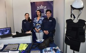 Dwie policjant i pracownica cywilna promują stoisko policyjne