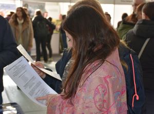 Kobieta przegląda ulotkę promującą prace w Policji