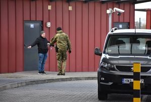 Funkcjonariusz Straży Granicznej kontroluje mężczyznę