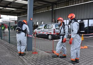 Strażacy w kombinezonach na przejściu granicznym