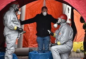 Mężczyzna w namiocie. Przy nim policjanci w kombinezonach.