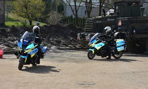 Policjanci na motocyklach. W tle koparki