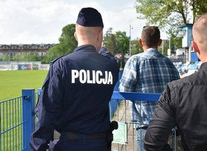 Policjant przed meczem. W tle płyta boiska
